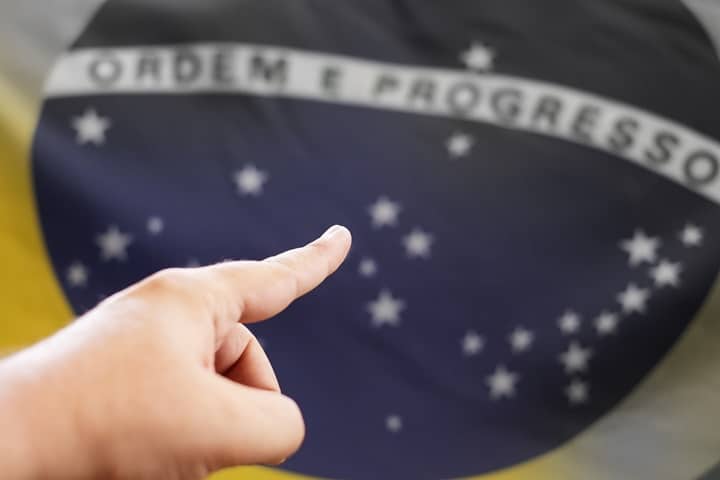 Mão apontando para Bandeira do Brasil