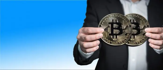 Mão segurando Bitcoin em duas mãos