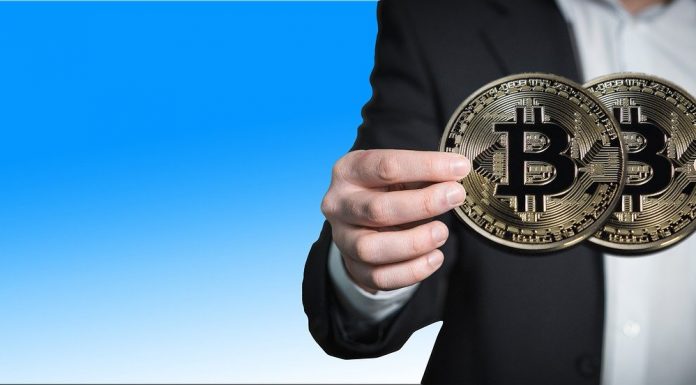 Mão segurando Bitcoin em duas mãos
