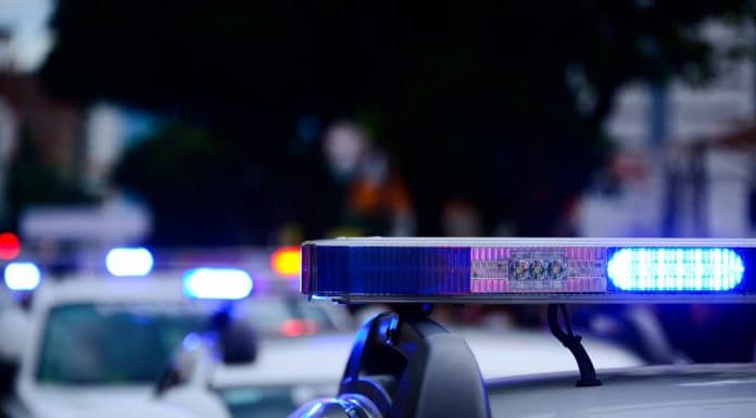 Carro de polícia com sirene ligada policiais criptomoedas Bitcoin
