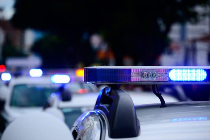 Carro de polícia com sirene ligada policiais criptomoedas Bitcoin