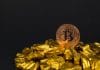 Bitcoin em cima de pilha de ouro