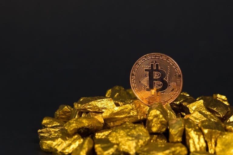 Bitcoin em cima de pilha de ouro