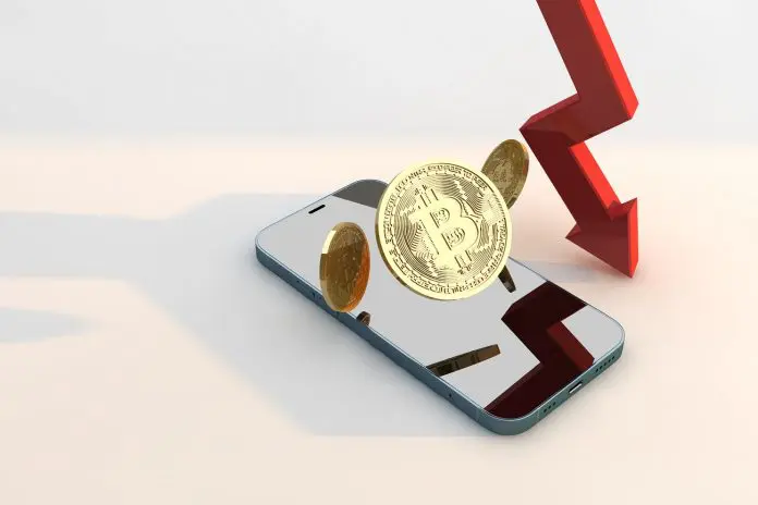 Bitcoin e seta de preço em queda em cima de celular