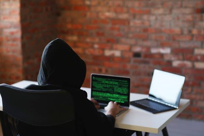 Hacker mexendo em notebook