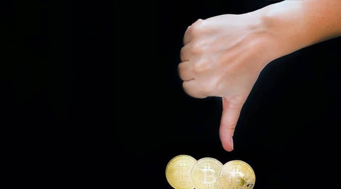 Sinal de negativo na mão com Bitcoin