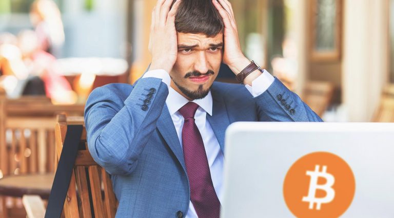 Homem desesperado com notebook com imagem do Bitcoin Imagem: Adobe Stock