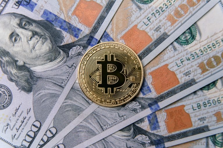 Criptomoeda Bitcoin sobre notas de Dólar dos Estados Unidos