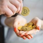 Mão cheia de Bitcoin aceitando moeda digital