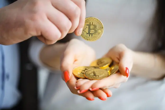 Mão cheia de Bitcoin aceitando moeda digital