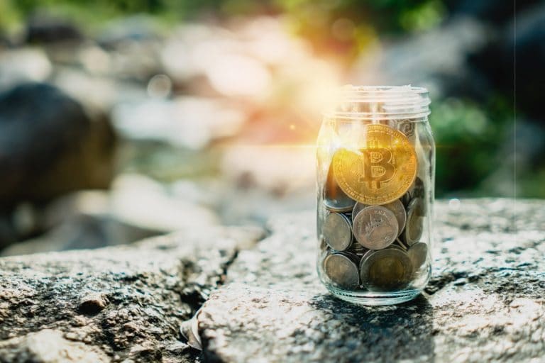 Bitcoin em cima de outras moedas em um pote