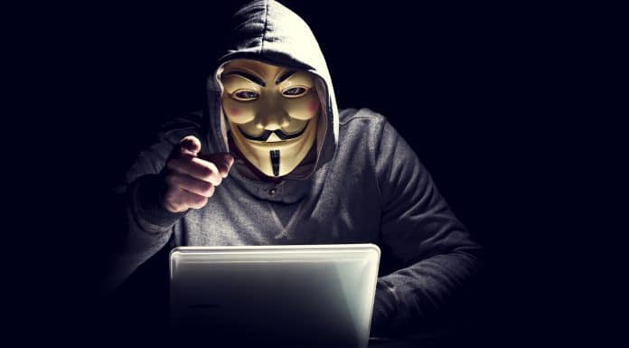 Hacker com máscara do Anonymous apontando dedo