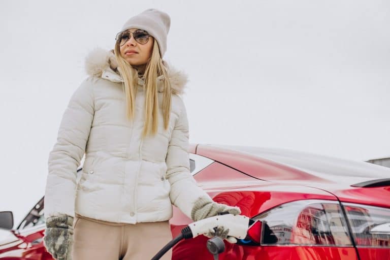 carros elétricos e Bitcoin, mulher recarregando veículo