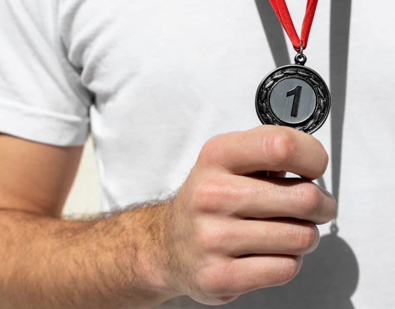 Pessoa segurando medalha número 1 olímpica NFT Olimpíadas