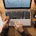Pessoa segurando um Bitcoin e trabalhando com a moeda