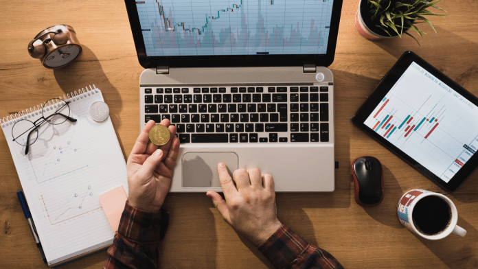 Pessoa segurando um Bitcoin e trabalhando com a moeda