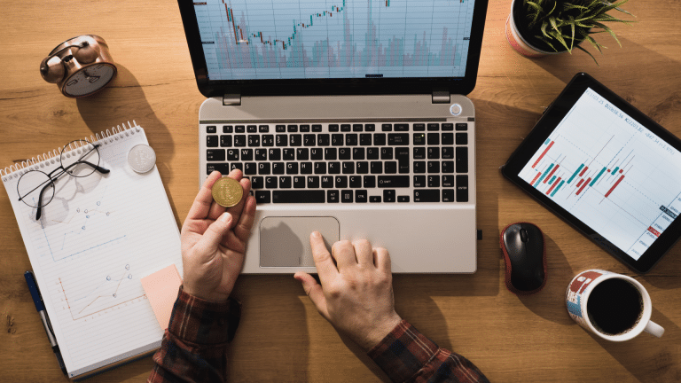 Pessoa segurando um Bitcoin e trabalhando com a moeda