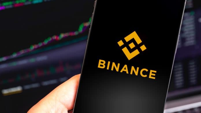 Aplicativo da Binance e gráfico de negociações ao fundo