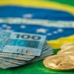 Bitcoin, Bandeira do Brasil e notas de Real brasileiro volume negociação