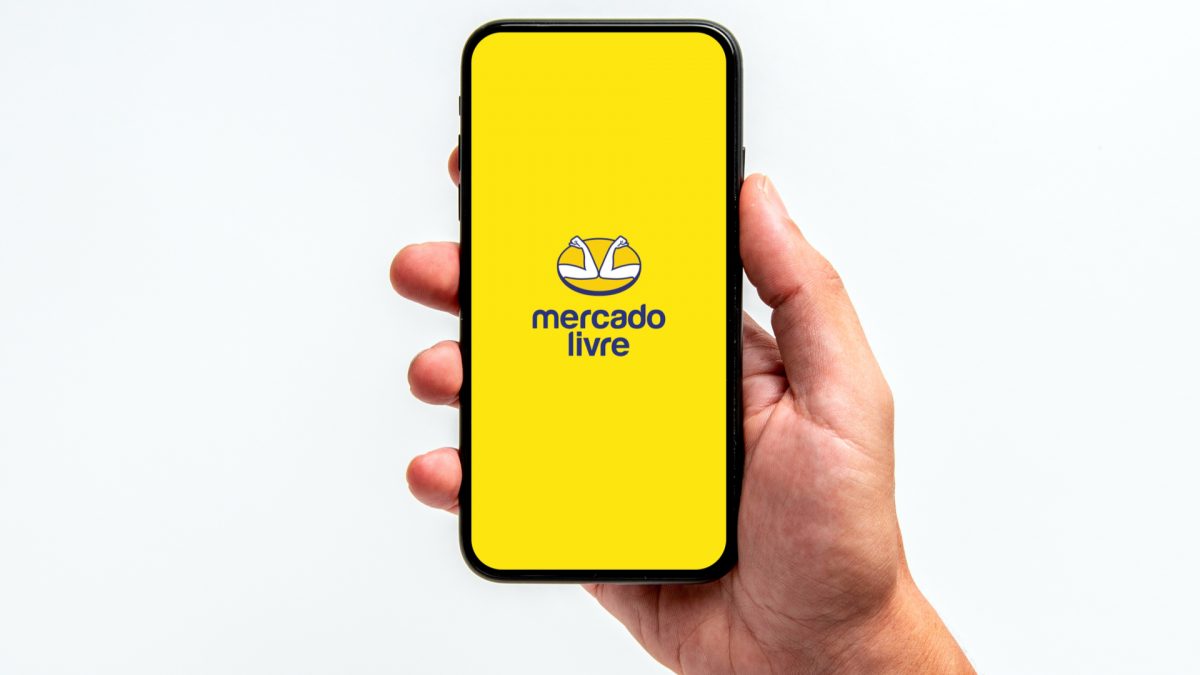 Celular com imagem do Mercado Livre na mão