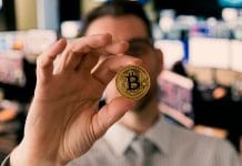 Homem trader segurando Bitcoin