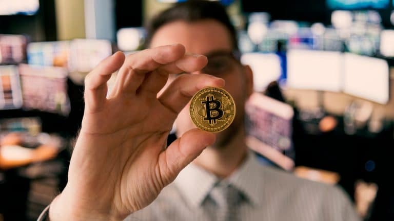 Homem trader segurando Bitcoin