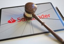 Martelo da justiça batendo em tablet com imagem do Santander
