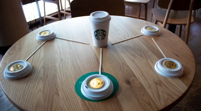 Mesa da Starbucks com moedas de Bitcoin em formato de M