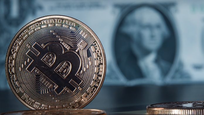 Moeda digital Bitcoin em destaque com Dólar no fundo