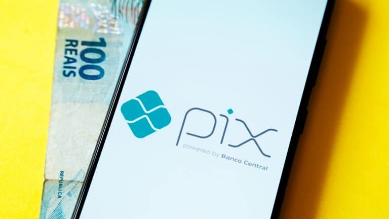 Celular com tela do PIX e nota de R$ 100 do Real brasileiro