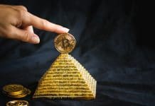 Mão segurando Bitcoin no topo de pirâmide líder
