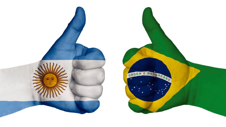 Mãos com bandeiras do Brasil e Argentina