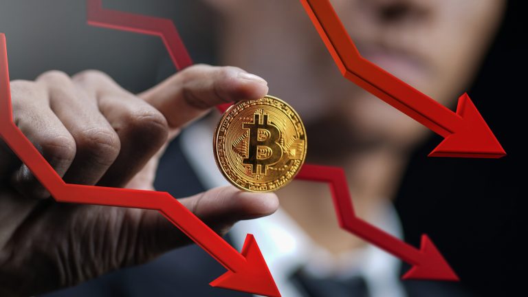 Trader segurando Bitcoin enquanto preço cai caindo queda despenca