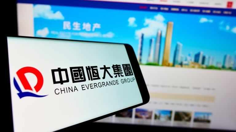 China Evergrande Group em tela de celular e computador Tether Bitcoin criptomoedas colapso crise
