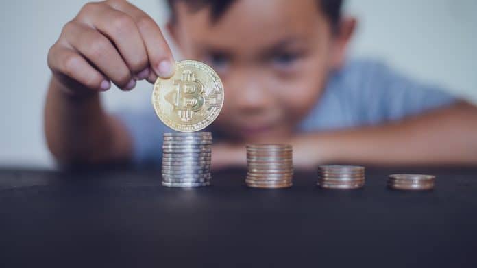 Criança segurando Bitcoin