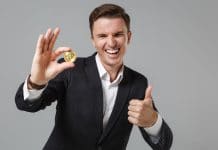 Homem segurando o Bitcoin e rindo