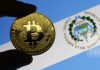 Mão segurando Bitcoin com bandeira de El Salvador