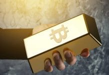 Mão segurando barra com símbolo do Bitcoin ouro