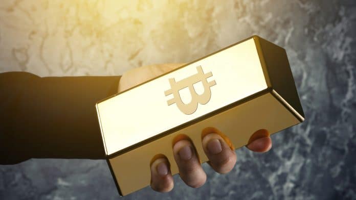 Mão segurando barra com símbolo do Bitcoin ouro