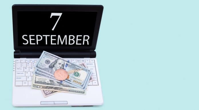 Notebook com a data de sete de setembro com Bitcoin e dólar em cima comprar
