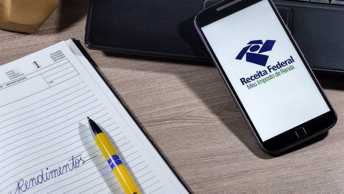 Aplicativo da Receita Federal do Brasil e caderno com a palavra Rendimentos