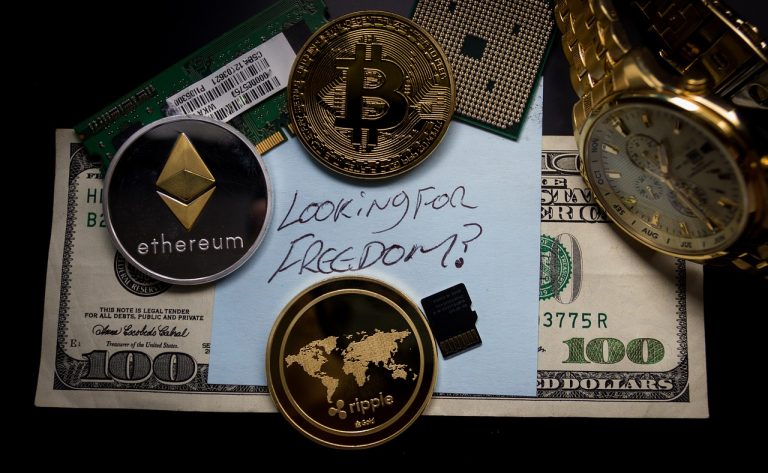 Criptomoedas próximas a uma folha com a frase Procurando por liberdade