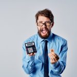 Homem de negócios desesperado segurando Bitcoin e calculadora imposto com criptomoedas