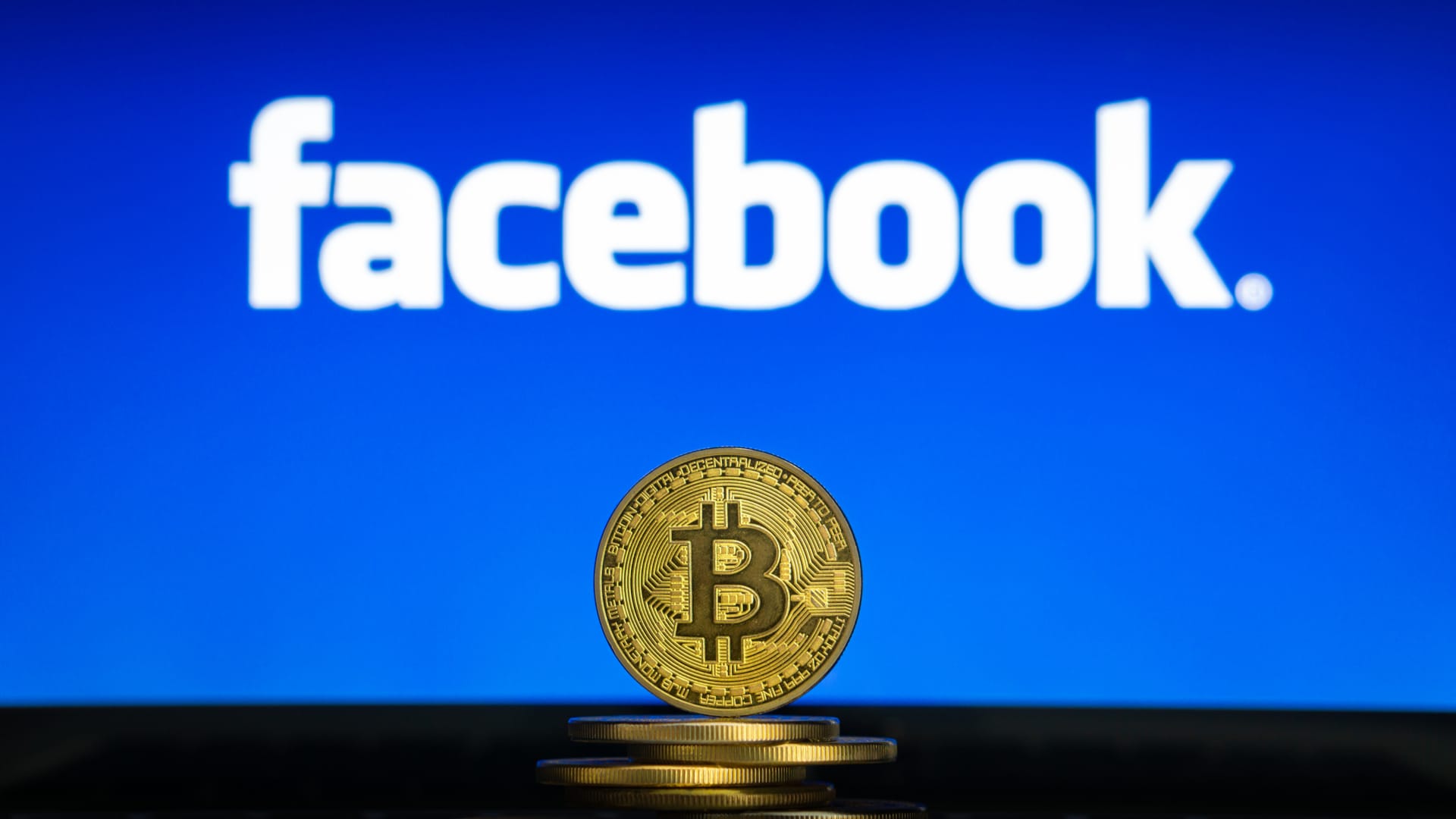 Moedas de Bitcoin em frente ao Facebook