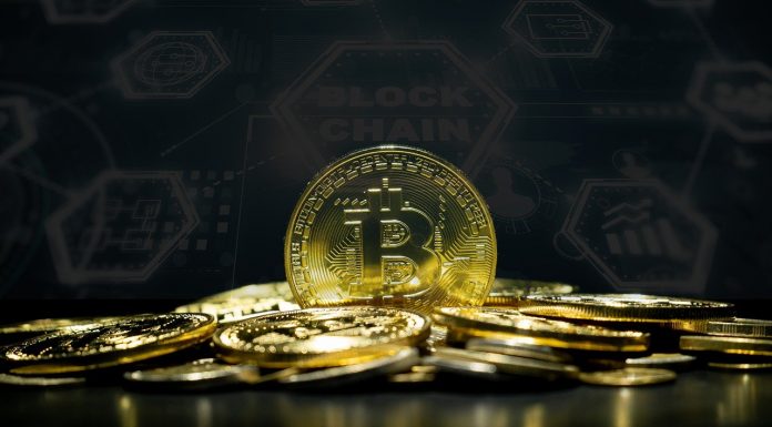 Monte de Bitcoin e ao fundo painel de blockchain