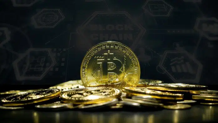 Monte de Bitcoin e ao fundo painel de blockchain