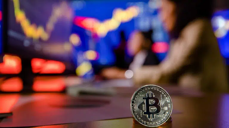 Bitcoin na frente com traders desfocados ao fundo