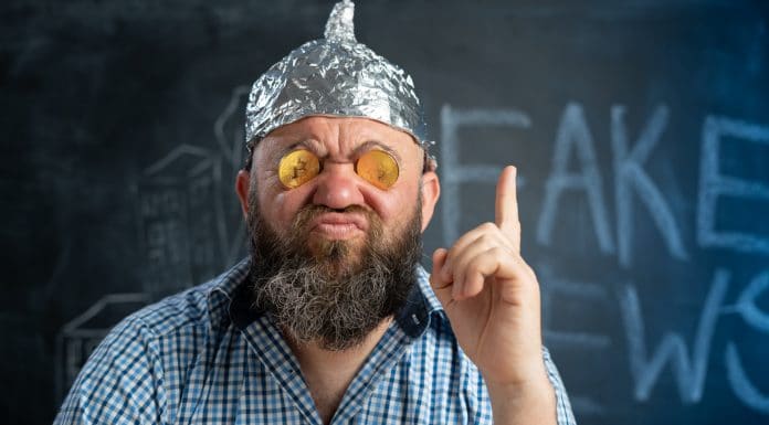 Homem com capacete de alumínio chamando Bitcoin de Fake News
