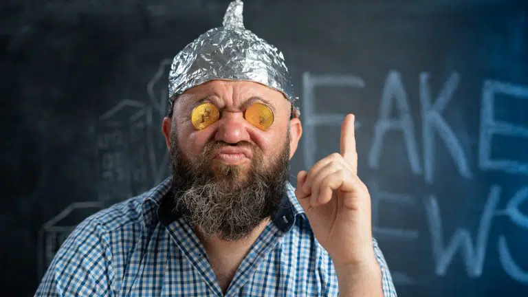 Homem com capacete de alumínio chamando Bitcoin de Fake News
