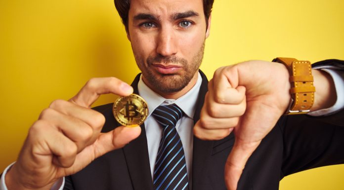 Homem desanimado com Bitcoin e apontando dedo para baixo
